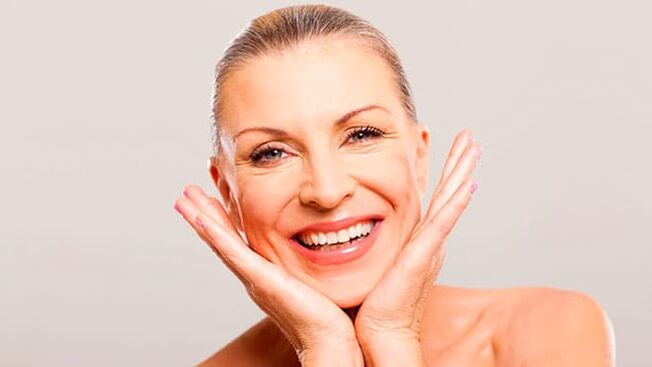 Happy woman in her 50s following facial skin care